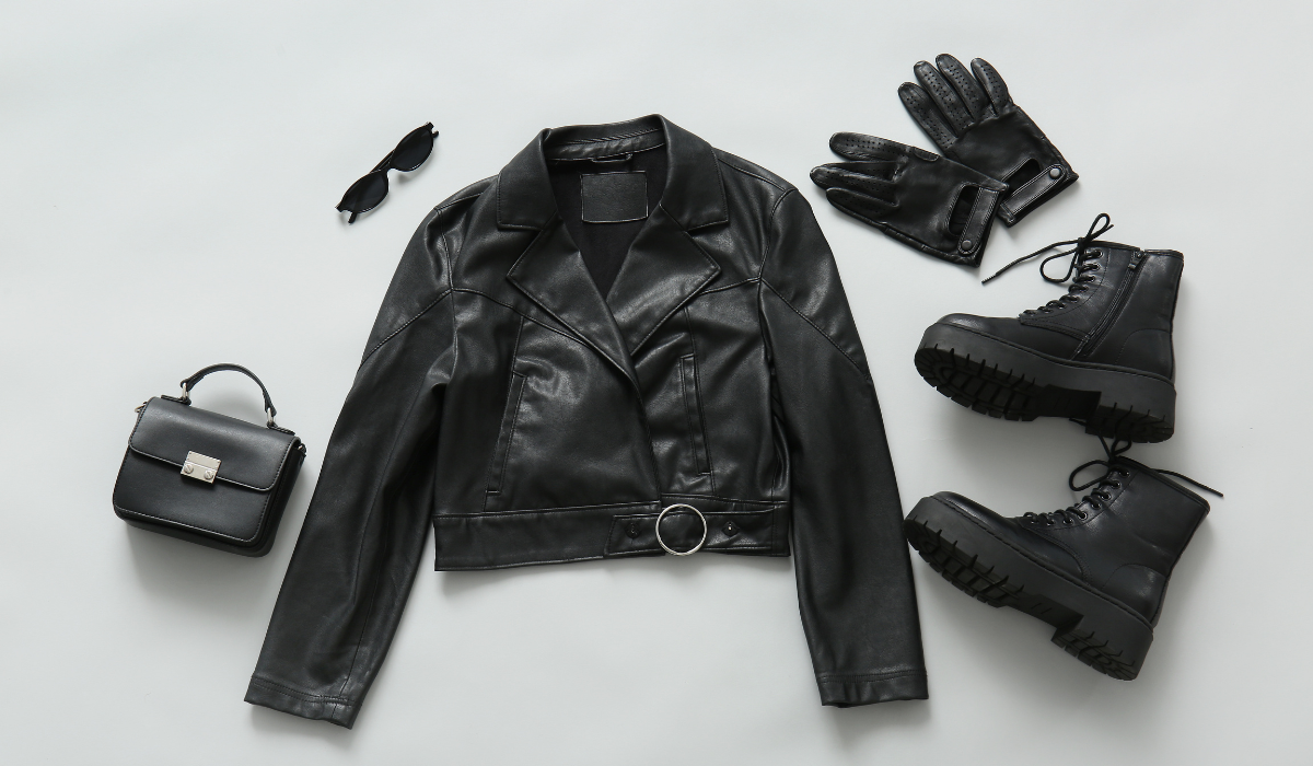 Black leather jacket, boots, gloves, and handbag flat lay - leather items that benefit from professional leather cleaning service on Long Island