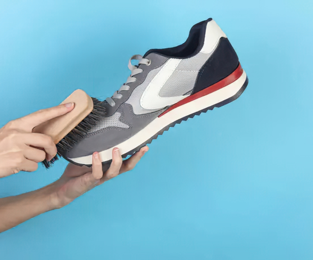 Premium sneaker being cleaned with a natural bristle brush